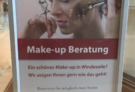 Auf dem Foto ist ein Schild für eine "Make-up Beratung" zu sehen, in dem in vier Zeilen drei Fehler sind.
